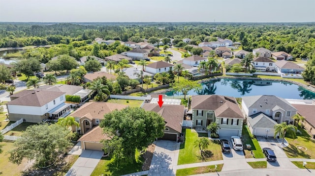 birds eye view of property featuring a water view, a residential view, and a view of trees