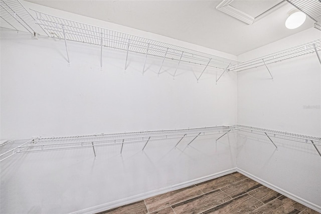 spacious closet with wood finish floors and attic access