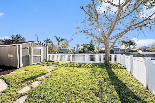 view of yard featuring an outbuilding, a storage shed, and a fenced backyard