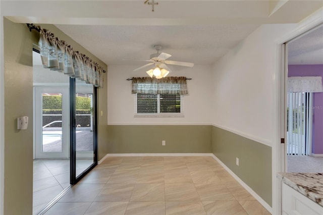 tiled empty room with ceiling fan