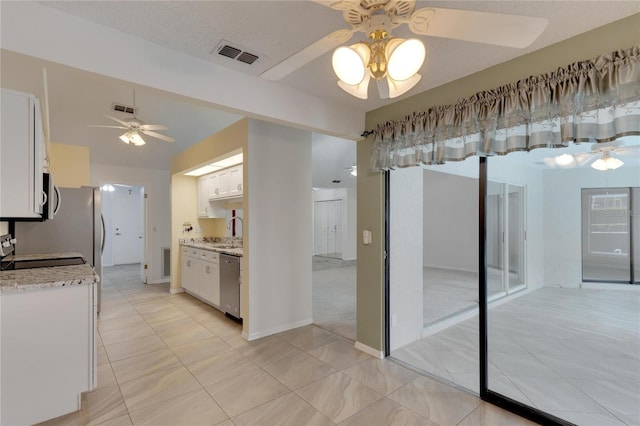 kitchen with appliances with stainless steel finishes, white cabinetry, sink, ceiling fan, and light tile patterned flooring