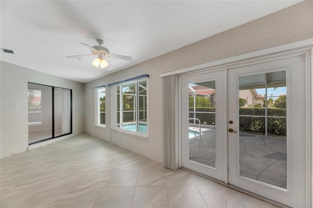 doorway to outside featuring a wealth of natural light, french doors, light tile patterned floors, and ceiling fan