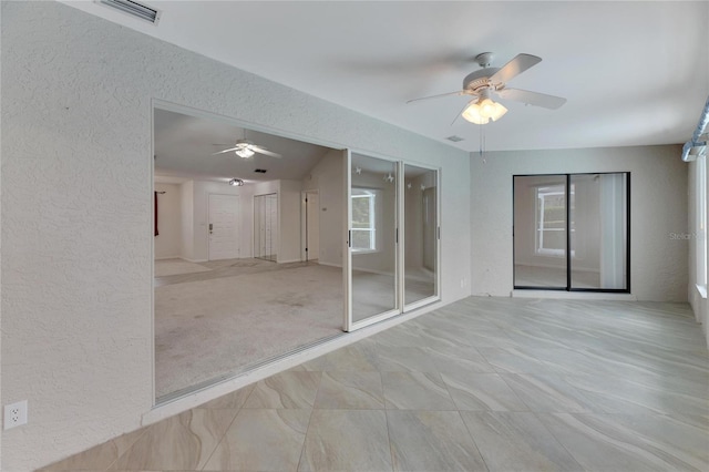 empty room featuring ceiling fan, light tile patterned floors, and a healthy amount of sunlight