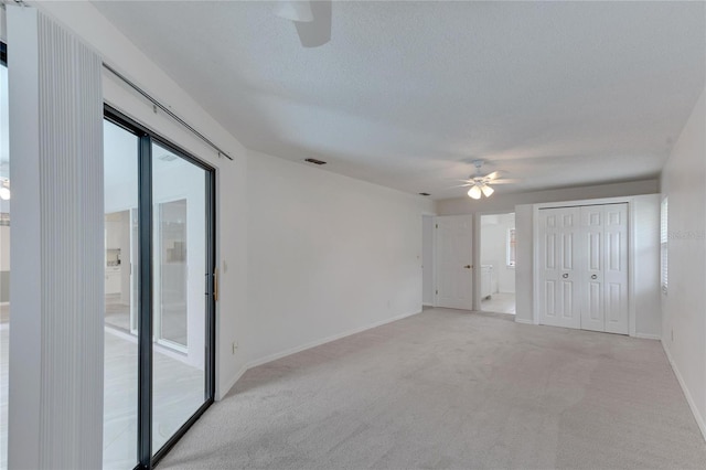 unfurnished bedroom featuring ceiling fan, a closet, access to outside, and light colored carpet