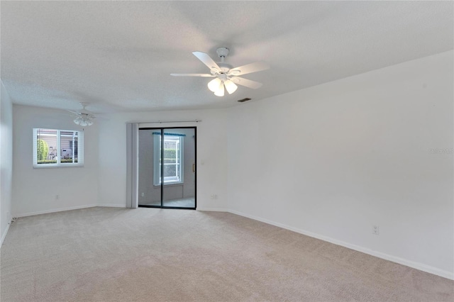 carpeted empty room with ceiling fan and a textured ceiling