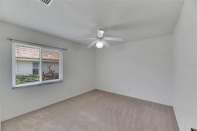 unfurnished room featuring ceiling fan, light carpet, and a textured ceiling