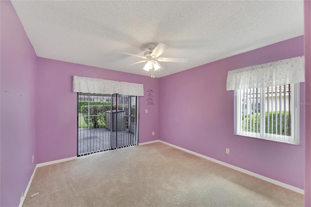 carpeted spare room with a textured ceiling and ceiling fan