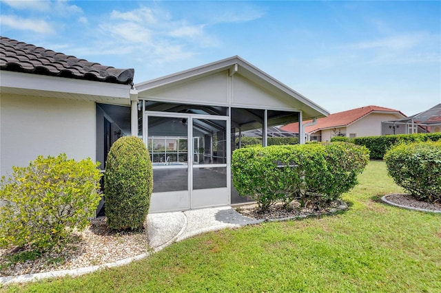 rear view of property with a sunroom and a yard