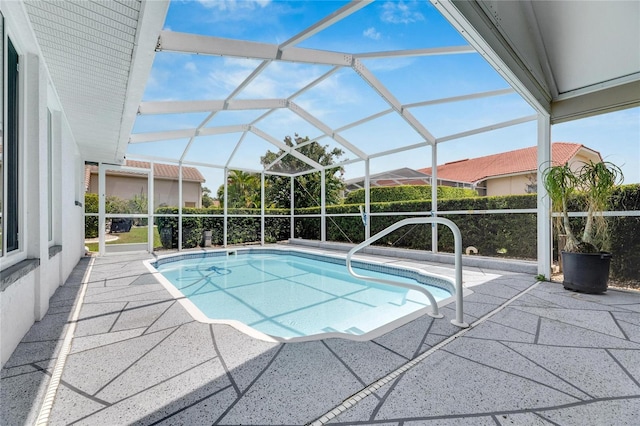 view of pool with glass enclosure and a patio