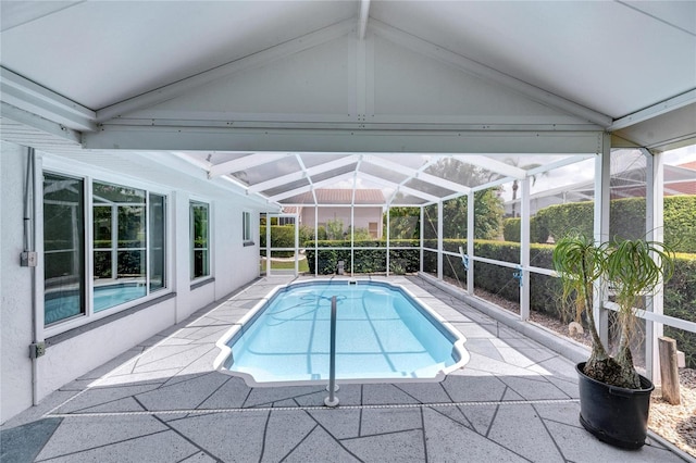 view of pool featuring glass enclosure and a patio area