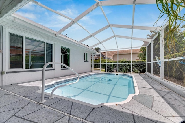 view of swimming pool with glass enclosure and a patio area