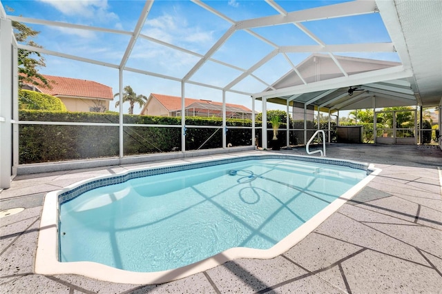 view of swimming pool featuring ceiling fan, a patio, and a lanai