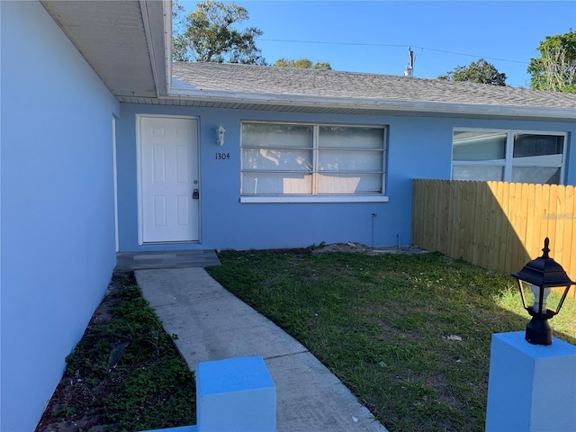 view of exterior entry with a yard