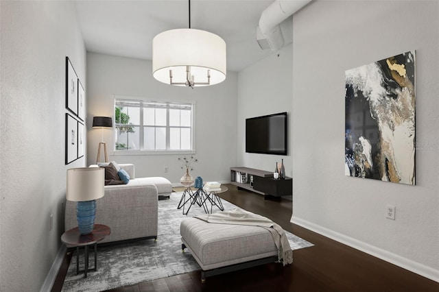 living room featuring dark wood-type flooring and an inviting chandelier