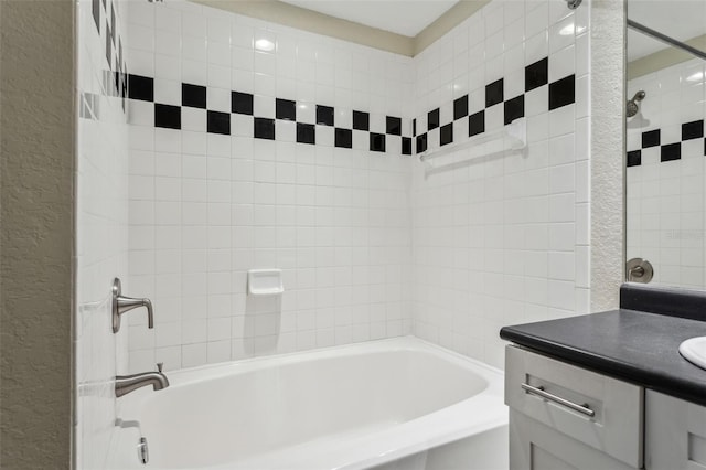 full bathroom featuring shower / bathtub combination, vanity, and a textured wall