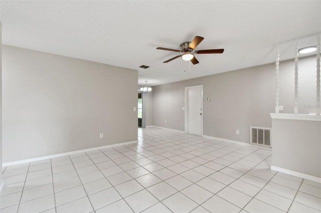 unfurnished room featuring light tile patterned flooring and ceiling fan with notable chandelier