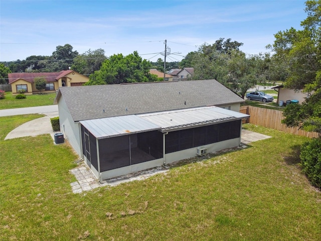 exterior space featuring cooling unit, a sunroom, and a yard