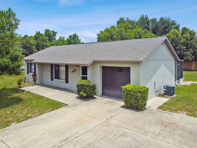 single story home with central air condition unit, a garage, and a front yard