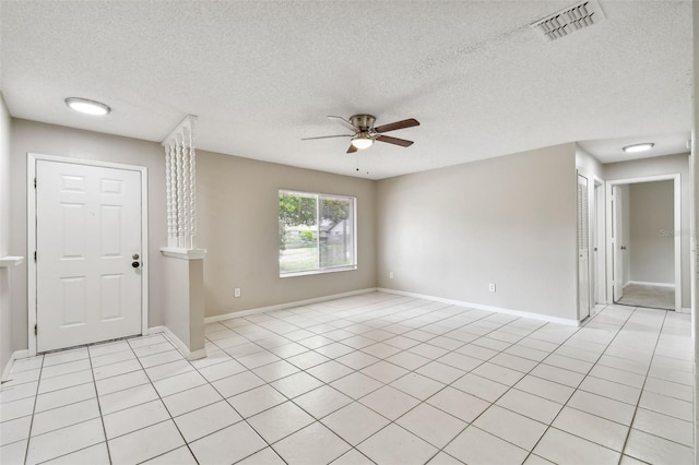 unfurnished room with ceiling fan, a textured ceiling, and light tile patterned floors