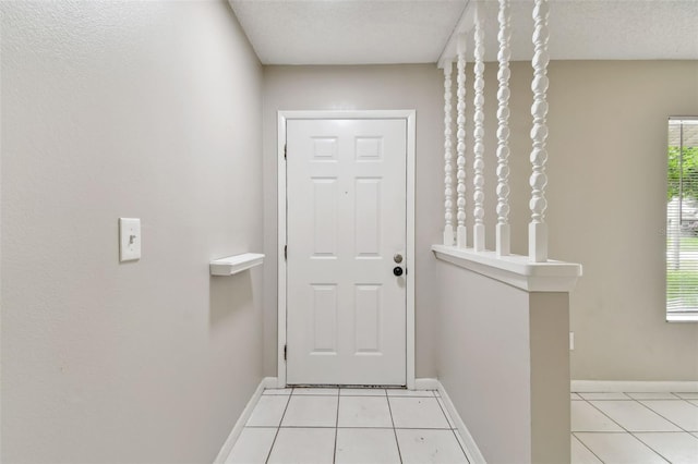 entryway featuring light tile patterned flooring and a textured ceiling