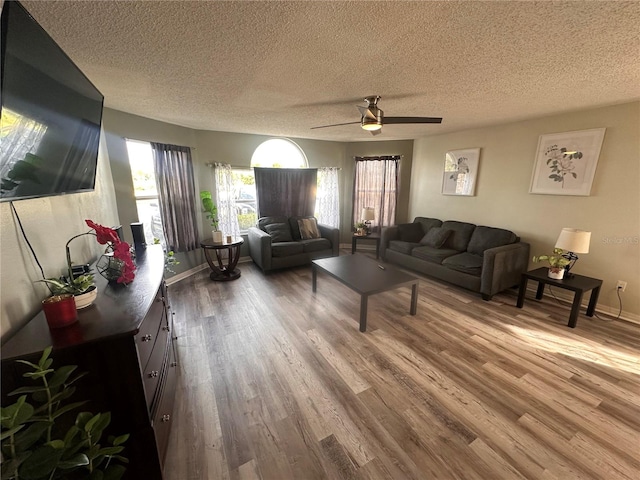 living room featuring a textured ceiling, ceiling fan, and wood-type flooring