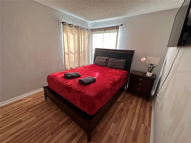 bedroom featuring a textured ceiling and wood-type flooring