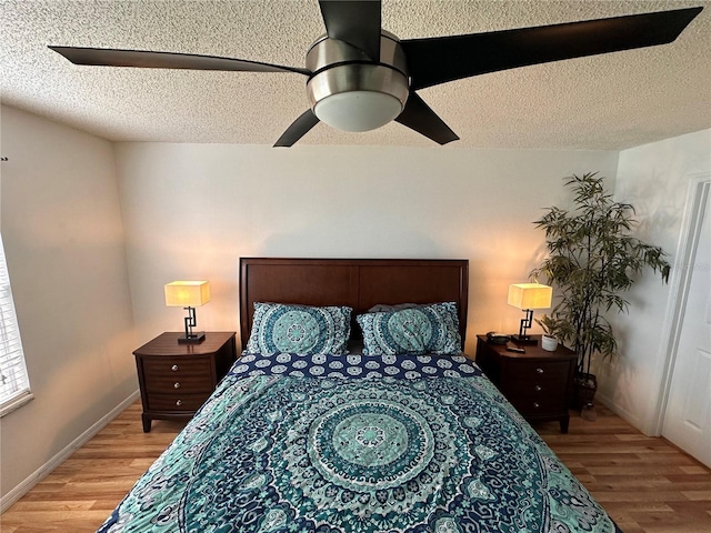 bedroom with a textured ceiling, hardwood / wood-style floors, and ceiling fan