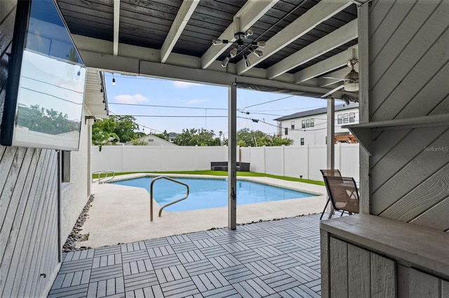 view of swimming pool featuring ceiling fan and a patio area