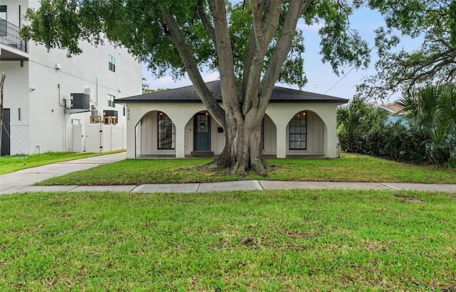 ranch-style home featuring central AC unit and a front yard