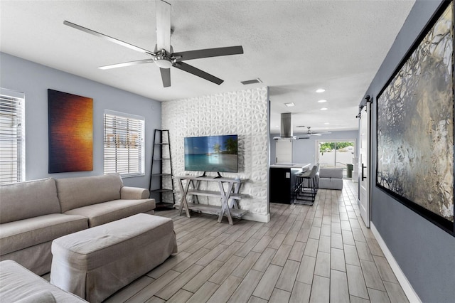 living room featuring a wealth of natural light, light hardwood / wood-style floors, and ceiling fan