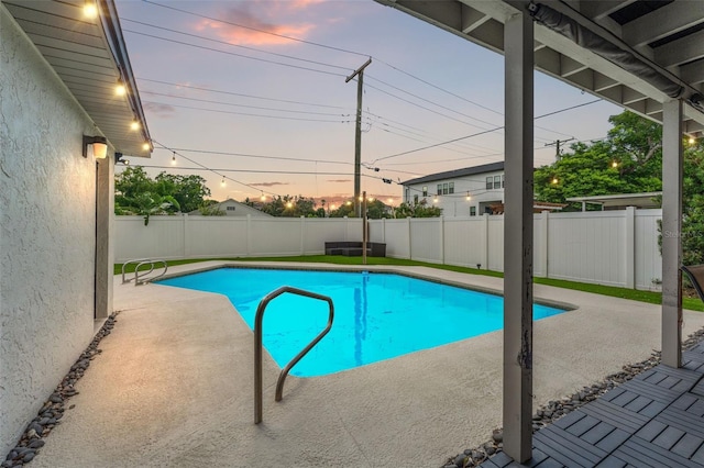 pool at dusk featuring a patio area