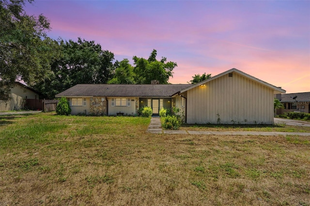 single story home featuring a lawn