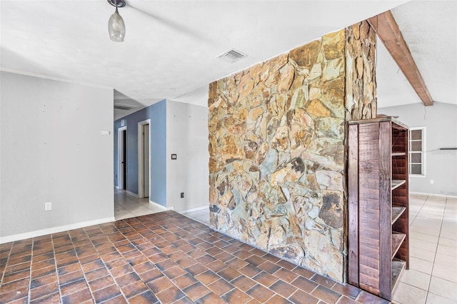 tiled empty room featuring beam ceiling