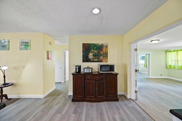 interior space with light wood-type flooring and a textured ceiling