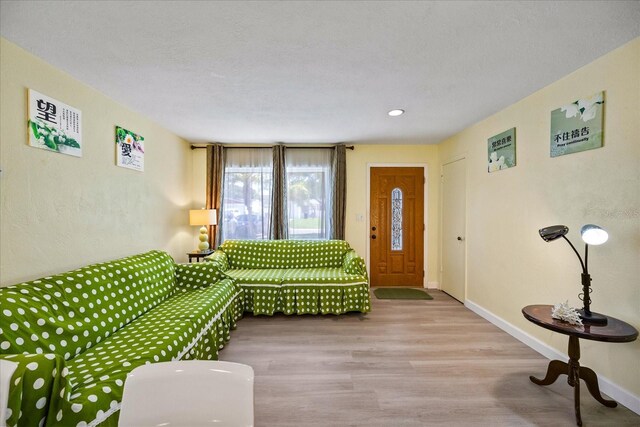 living room featuring wood-type flooring and a textured ceiling