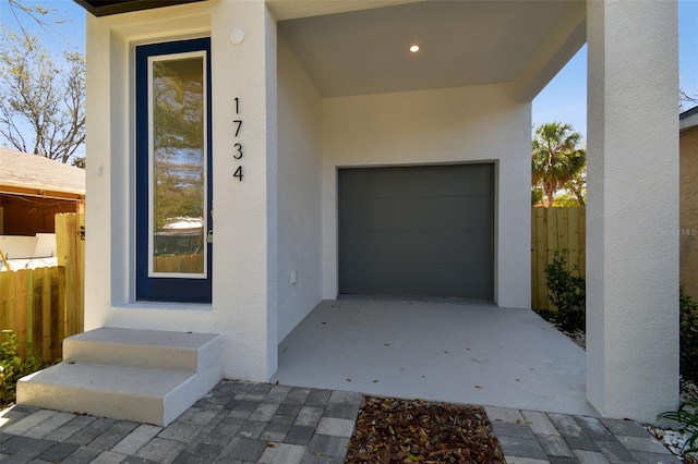 property entrance with fence and stucco siding