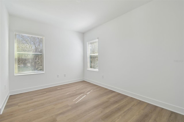 empty room with light wood finished floors and baseboards