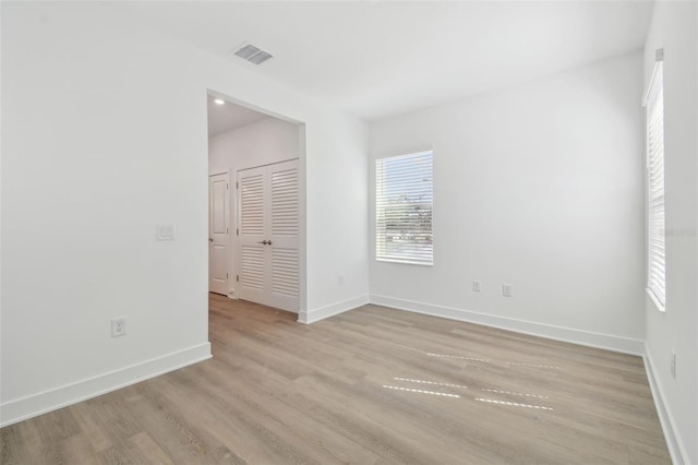 interior space with light wood-style floors, baseboards, visible vents, and a closet