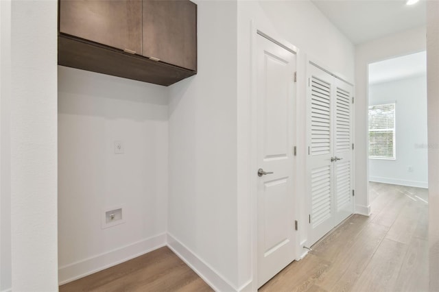 hall with light wood-style floors and baseboards