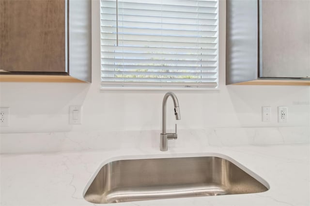 room details with a sink and light stone countertops