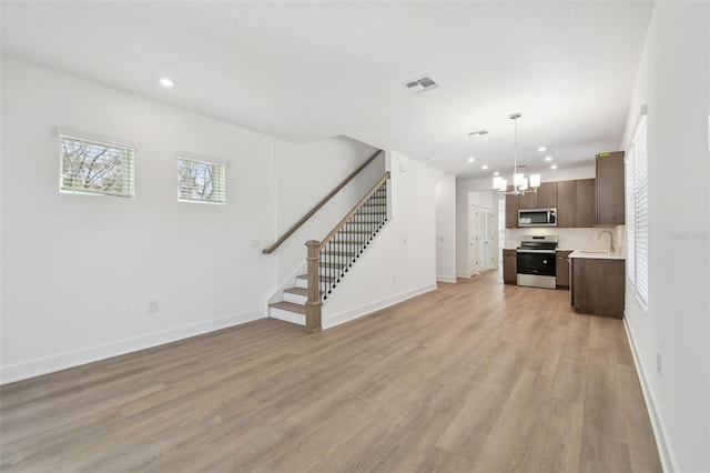 unfurnished living room featuring recessed lighting, visible vents, baseboards, stairway, and light wood-type flooring