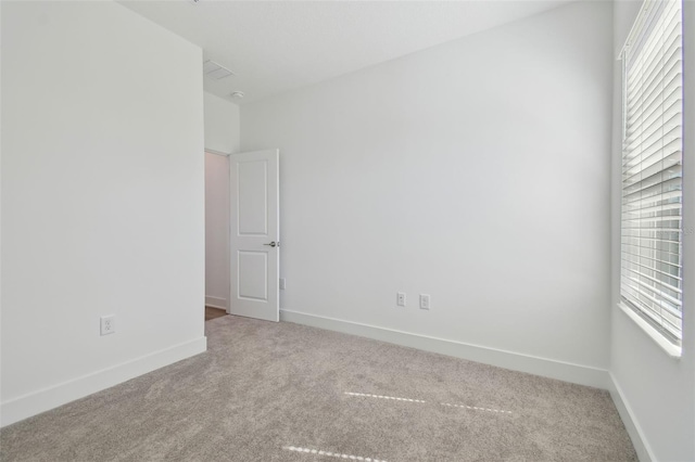 empty room with carpet floors, plenty of natural light, and baseboards