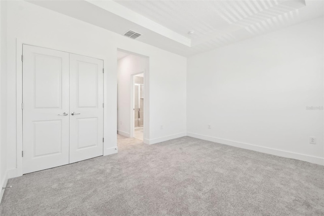 unfurnished bedroom with carpet floors, a closet, visible vents, connected bathroom, and baseboards