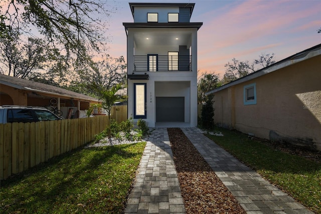 view of front of home with fence, a balcony, and stucco siding