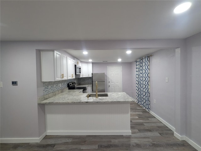 kitchen featuring kitchen peninsula, stainless steel appliances, white cabinets, and dark wood-type flooring