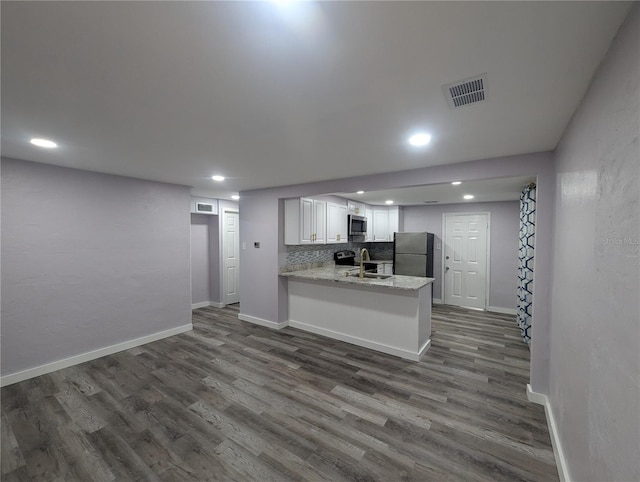 kitchen featuring white cabinetry, kitchen peninsula, dark wood-type flooring, and stainless steel appliances