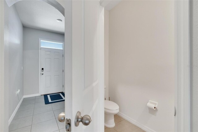 bathroom featuring toilet and tile patterned flooring