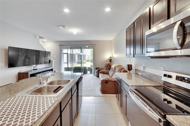 kitchen featuring sink, light carpet, appliances with stainless steel finishes, and dark brown cabinetry