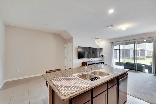 kitchen with sink, light tile patterned flooring, a kitchen island with sink, and dishwasher