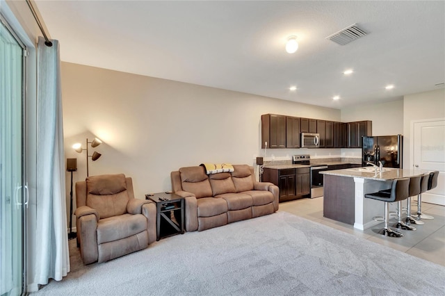 living room featuring sink and light carpet